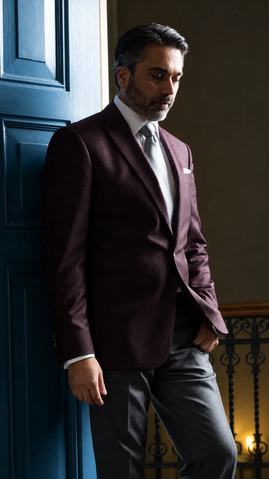 De directeur van Diya Tailors in een bordeaux maatcolbert